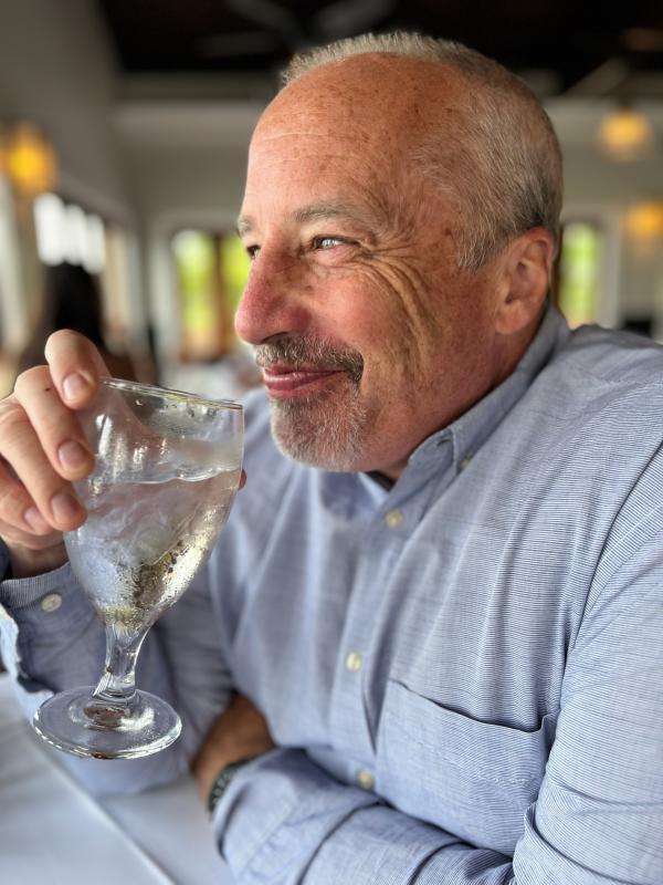 man drinking a glass of water and smiling